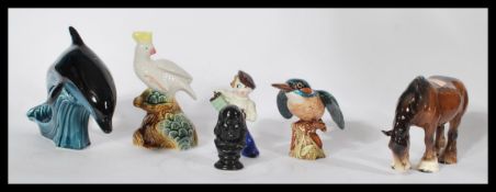 A collection of ceramics to include a Poole pottery dolphin, a Brazilian Cockatoo, a Beswick horse