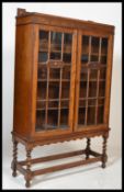 A good 1920's oak barley twist china display cabinet / bookcase. Raised on barley twist legs