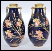 A pair of Old Hall tubeline twin handled vases with floral decoration in the manner of Moorcroft.