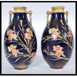 A pair of Old Hall tubeline twin handled vases with floral decoration in the manner of Moorcroft.