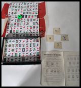 A vintage retro 20th century Mahjong set having white and orange tiles. Complete in case.