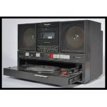 A retro 20th Century Panasonic portable record player, tape player and radio combo