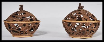 A pair of early 20th century carved coconut Potpourri pots with lids carved with leaves having