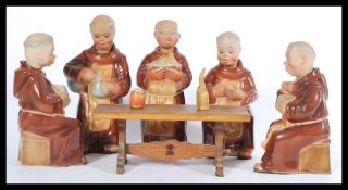 A group of five vintage 20th Century ceramic  decanters modelled as monks, sat around a miniature