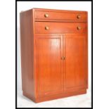 A 1930's Art Deco oak tallboy chest having twin cupboard doors with linen shelved interior with