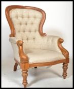 A Victorian style mahogany spoon back armchair raised on reeded turned legs with button backed