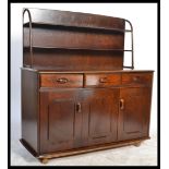 An Ercol style room divider sideboard with upright gallery back over shaped wide body on castors