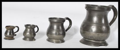 A set of four 18/19th century graduating pewter measures of bulbous form with shaped handles and