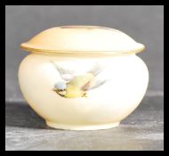 A Royal China Works Grainger Worcester lidded pot hand painted and decorated with birds depicting