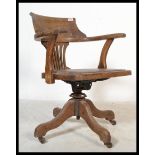 An early 20th century Industrial office swivel chair / desk armchair being raised on quadruped