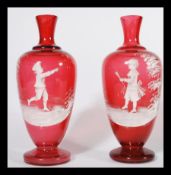 A pair of Mary Gregory style cranberry glass vases