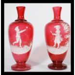 A pair of Mary Gregory style cranberry glass vases