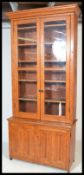 A late Victorian large Arts and Crafts Golden Oak library bookcase twin glazed doors on low base