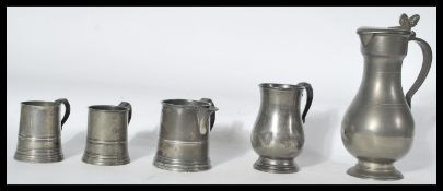 A group of 18th / 19th century pewter to include a tall ewer jug with twin acorn finial lid , a