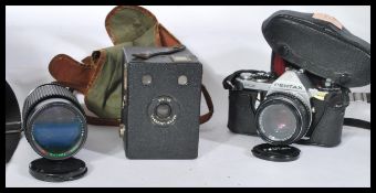 A vintage Pentax ME 35mm camera with lenses and a boxed brownie camera.