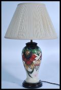 Moorcroft pottery table lamp, baluster-shaped with tube-lined decoration of various flowers together