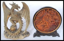 A 20th century hand carved statue figurine of a dragon on naturalistic base along with a carved