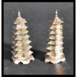 A pair of early 20th century Chinese silver pepperettes in the form of pagoda buildings. The seven