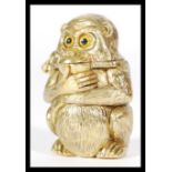 A brass Vesta case in the form of a squat monkey deep in thought, hinged top with strike to base.