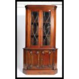 A good quality mahogany Georgian revival corner cabinet raised on plinth base with cupboard having a