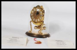 A good brass mechanical wind up Kuntz anniversary clock under glass dome, with original