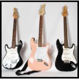 A collection of three electric six string Guitars to include a pink Fortism, an Encore and a 3/4