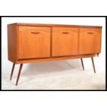 A 1970's retro teak wood long john sideboard comprising  a series of 3 cupboards with shaped handles