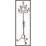 A 20th century wrought metal ebonised standard lamp having twist column with scrolled leg supports