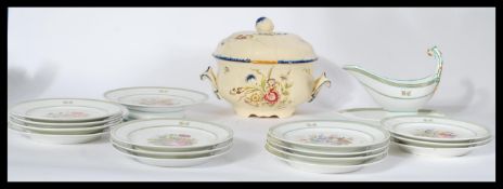 An early 20th century French ceramic hand painted part service consisting of a tazza , 14 plates and