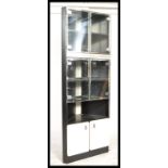 A retro 20th Century corner unit display cabinet, smoked glass doors with fitted white panel