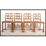 A set of four 20th Century Art Deco oak dining chairs, the chairs raised on turned legs united by