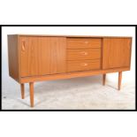 A retro 20th Century teak effect sideboard having a central bank of three drawers flanked by sliding