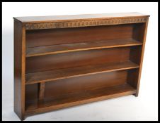 An antique style oak open window bookcase cabinet raised on a plinth base with central shelf and