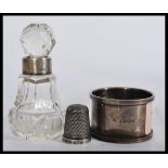 A group of hallmarked silver items to include a napkin ring , thimble and a collared cut glass