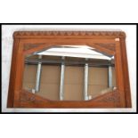 An early 20th Century carved oak over-mantle mirror carved detail to the mirror back with an