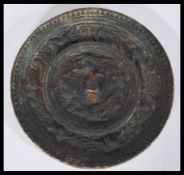 An antique Chinese circular bronze hand mirror of circular form decorated with dragns and dogs of