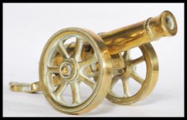 An early 20th century heavy cast brass desk top cannon dated 1812, Moving wheels with detachable