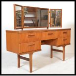 A retro 20th century teak wood Danish inspired sideboard dressing table having an arrangement of