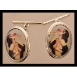 A pair of sterling silver and enamel cuff links depicting a semi nude lady. Weighs 9.6 grams.