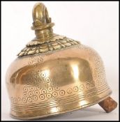 A 19th century Indian brass cow bell having chased