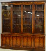 A good flame mahogany large breakfront library bookcase cabinet being raised on a plinth base with a