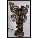 A good quality 20th century table lamp in the form of a fairy with decorative wings in a Tiffany