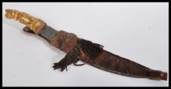 A vintage 20th century Tibetan dagger having a car