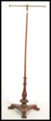 A 19th century Victorian rosewood valet / parrot stand having a carved tripod base with brass T pole