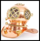 A vintage copper and brass desktop model of an antique deep sea divers helmet with clear acrylic