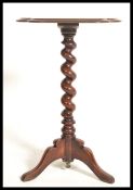 A 19th century Victorian mahogany wine side occasional table raised on tripod legs with barley twist