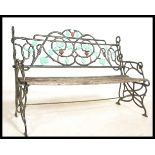 A vintage weathered garden bench having an ebonised cast iron back with painted leaf and vine