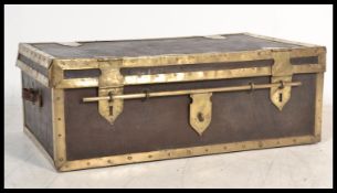 An antique large decorative leather and brass bounded trunk with side carry handles having sliding