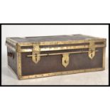 An antique large decorative leather and brass bounded trunk with side carry handles having sliding