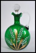 A 19th century green glass decanter with stopper decorated with sprays of lily of the valley